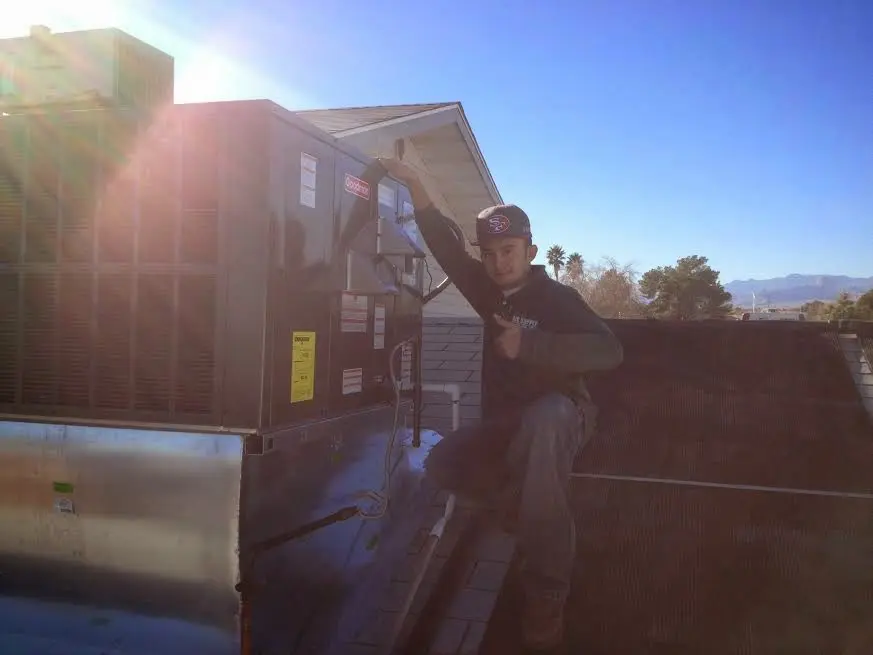 HVAC technician performing Heat Pump Repair on a rooftop unit in Nicholasville